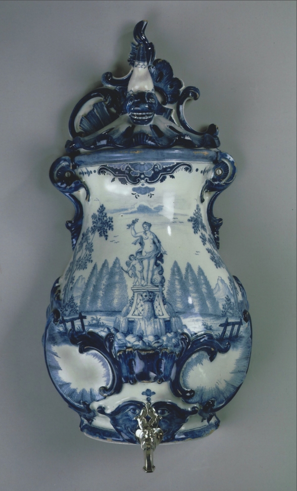 A Dutch wall fountain, blue and white faience with the original silver tap